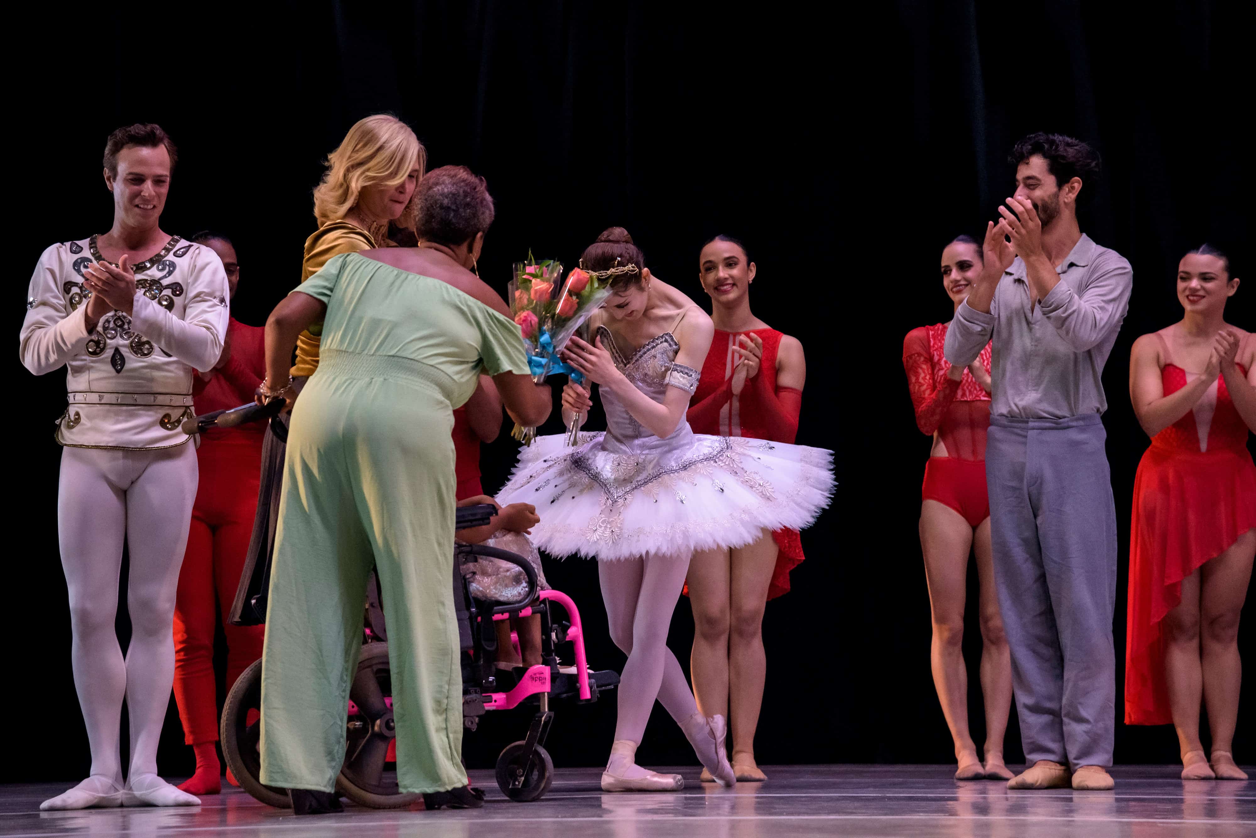 Una niña de la fundación Nido para Ángeles regaló rosas al elenco de bailarines al final de la obra